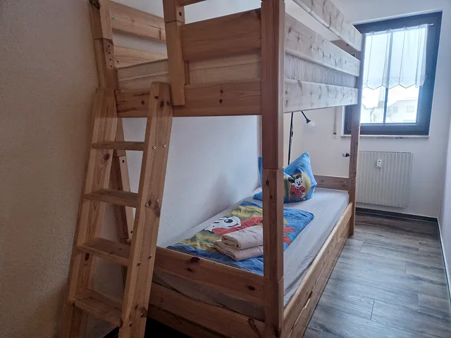 Schlafzimmer mit Etagenbett aus hellem Holz