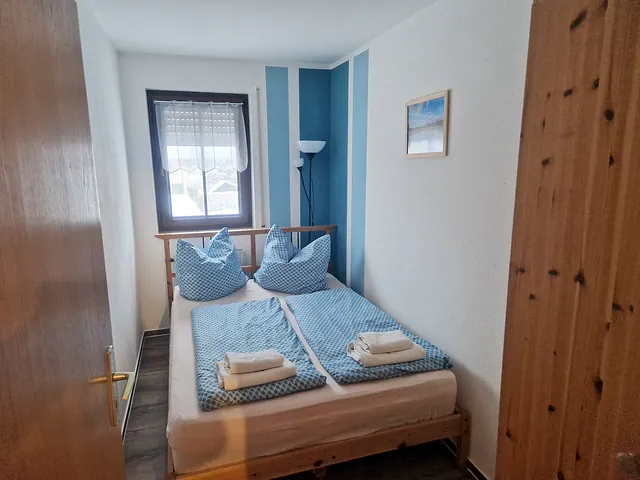 Gemütliches Schlafzimmer mit Doppelbett und blauer Bettwäsche